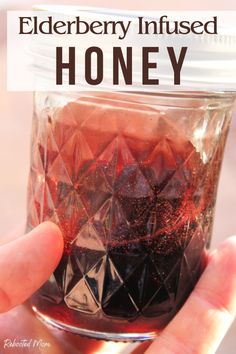 someone is holding up a jar with honey in it and the words elderberry infused honey