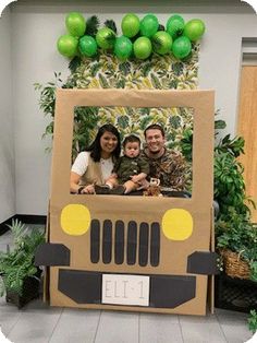 two people and a child are in a cardboard jeep