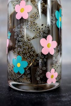 a glass jar filled with flowers on top of a table