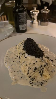 a white plate topped with whipped cream and black sprinkles on top of it