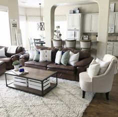 a living room filled with lots of furniture and decor on top of a white rug