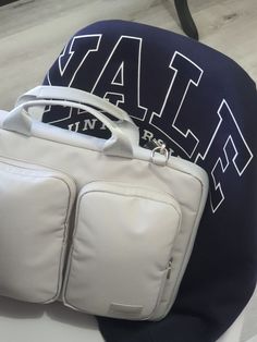 a white bag sitting on top of a table next to a blue pillow with the word utah printed on it