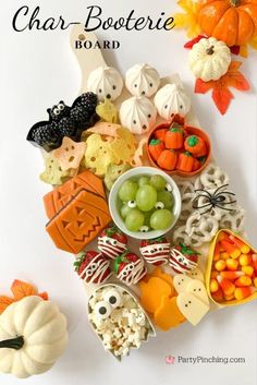 a white table topped with lots of halloween treats and candies on top of it