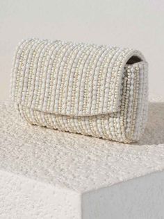 Get ready to add some serious fun and flair to any outfit with our Danny Beaded Clutch. With a magnetic snap closure and inner slip pocket, this clutch is as functional as it is stylish. Made from a unique blend of cotton and glass beads, and featuring a detachable cross-body chain and gold hardware, it's the perfect statement piece for any occasion. General Info: Magnetic Snap Closure 1 Inner Slip Pocket Detachable Cross-Body Chain - 23" Made from Cotton and Glass Beads Gold Hardware 7.25" L x 2" W x 5" H Beaded Clutch, Clothing Company, Gold Hardware, Handbag Accessories, Statement Pieces, Glass Beads, Chain, Beads, Gold