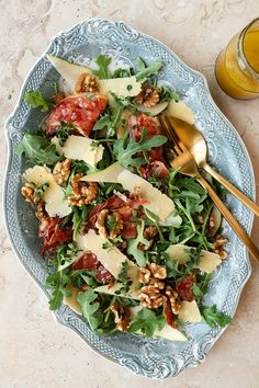 a blue plate topped with salad next to a glass of orange juice