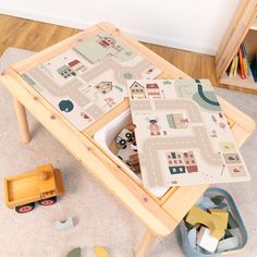 a child's play table with toy cars and toys on the floor next to it