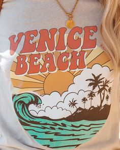 Best Seller Classic Tee Fit 52% Cotton and 48% Polyester Machine Wash Cold. Tumble Dry Low Crew Neckline Short Sleeves Front Graphic Reads ¡° Venice Beach" No Closures Not Lined //Best Seller// Hang by the beach in the Retro Wave Venice Beach Cotton Blend Tee with a stone base that has a coral. orange. yellow. white. mint. and charcoal graphic.Styled with: Gabi Hoops. Kramer Toggle Necklace. Hillock Bag. Marina Sandal. and Todd Shorts.---SIZE AND FIT---Model is Wearing a Size Small. Height is 5' Off Shoulder Evening Gown, Retro Wave, Retro Waves, Mini Skater Dress, By The Beach, Coral Orange, Skater Style, Venice Beach, Bold Prints