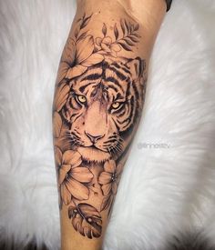 a black and white tiger with flowers on it's leg, done by an artist