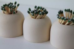 three white vases with toothpicks sticking out of them