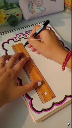 a person is using a ruler to measure the height of a piece of paper on top of a table