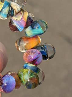 a hand holding a bunch of glass beads