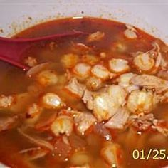 a red spoon in a bowl filled with soup