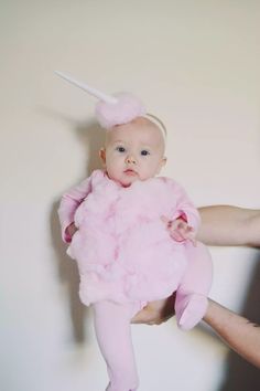 a person holding a baby in a pink dress