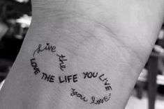 a person with a tattoo on their arm saying live the life you love