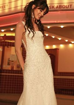 a woman in a wedding dress is posing for the camera