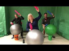 three people sitting on exercise balls in front of a green backdrop holding up their arms