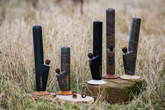 five pieces of wood sitting on top of a tree stump in the middle of a field