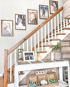 the stairs are decorated with pictures and frames for family photos on them, along with two baskets filled with succulents