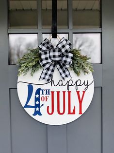 a happy fourth of july sign hanging on the front door of a house with wreath