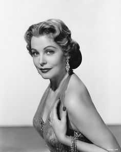 an old black and white photo of a woman in a dress with her hands on her chest