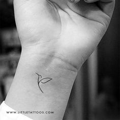 a small tattoo on the wrist of a woman's left hand, with a single flower