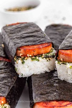 several pieces of sushi on top of rice and garnished with sesame seeds