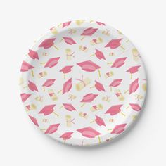 a paper plate with pink and yellow graduation caps on it, against a white background