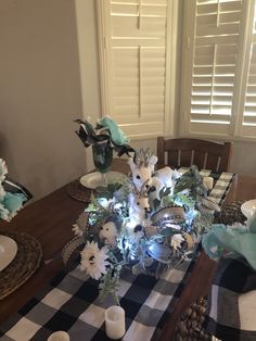 a dining room table is set with flowers and candles