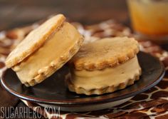 two cookies on a plate with peanut butter frosting and a glass of orange juice in the background