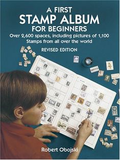 a young boy looking at stamps on a sheet of paper with the title, a first stamp album for beginners over 600 spaces, including pictures of 100 stamps from all over the world