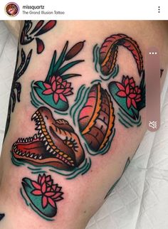 an image of a tattoo on the leg with flowers and snakes coming out of it