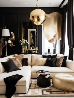 a living room with black walls and white couches, gold accents on the ceiling