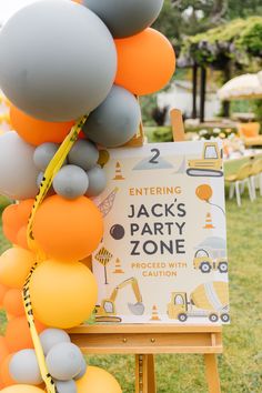 an outdoor party with balloons and signs