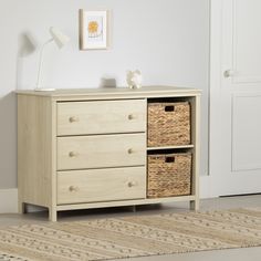 a white dresser with two wicker baskets on top