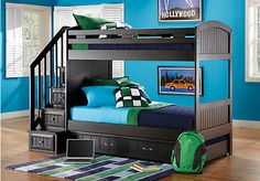 a bunk bed with blue walls and green pillows on the bottom bunk is next to a rug