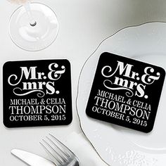 two personalized coasters sitting on top of a white plate next to silverware