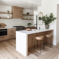 a kitchen with two stools and an island in front of the stove top oven