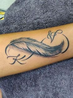 a woman's arm with a tattoo on it and a feather in the middle