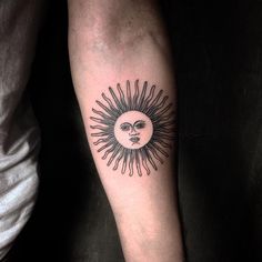 a man's arm with a sun and moon tattoo on the left inner arm