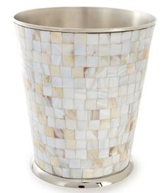 a white and gold mosaic waste basket on a metal stand with a silver rim around it