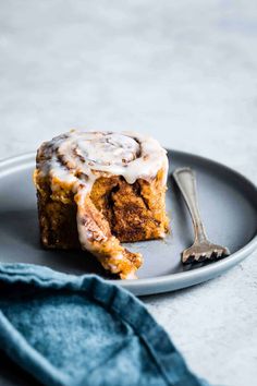 a piece of cinnamon roll on a plate with a fork