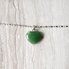 Beautiful heart jade necklace, Gorgeous translucent green. The pendant is made from nephrite jade mined from British Columbia, Canada. We currently only have the gold plated jump ring in stock. The pendant comes with a stainless steel jumpring. Option to buy sterling silver chain necklaces. Jade brings harmony and contentment to the wearer. In Asian cultures, Jade is revered as the good luck stone which can bring happiness, wealth, and friendship. 15mm x 15mm x 4.85mm 4.6 grams Dainty Green Heart Pendant Necklace, Green Double Heart Jewelry With Heart Charm, Green Double Heart Charm Jewelry, Green Heart Cut Necklace For Gift, Green Heart Necklace With Charm For Valentine's Day, Green Heart Charm Necklace For Valentine's Day, Green Heart Necklace For Valentine's Day Gift, Valentine's Day Green Necklace With Heart Charm, Green Heart Pendant Necklace With Charm