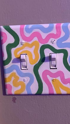 a colorful light switch cover with swirls painted on it