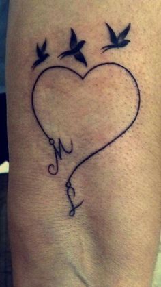 a heart tattoo with birds flying around it