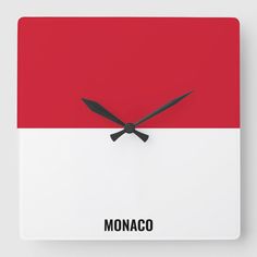 a red and white square clock with the word monaco in black on it's face