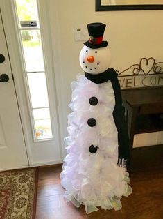 a snowman made out of plastic bottles on the floor in front of a door