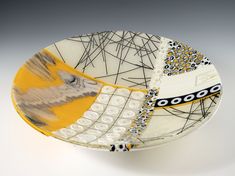 a yellow and white plate with an abstract design