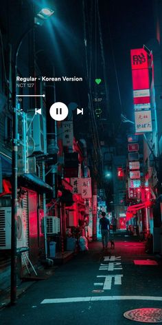 a person walking down an alley way at night with red lights on the buildings and signs