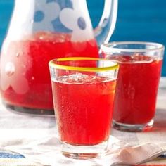 a pitcher and two glasses filled with red liquid