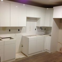 an unfinished kitchen with white cabinets and appliances